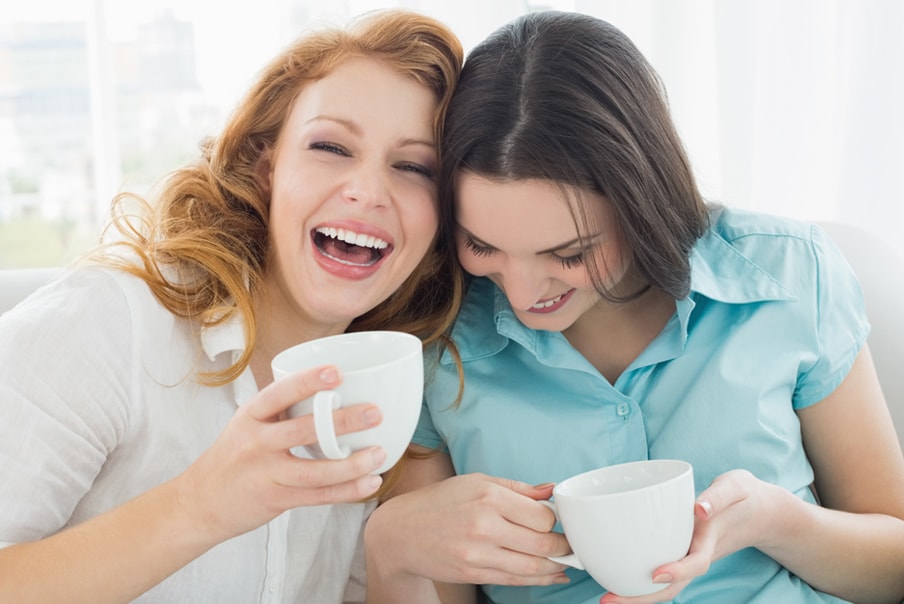 Ragazze sorridenti bevono da tazza