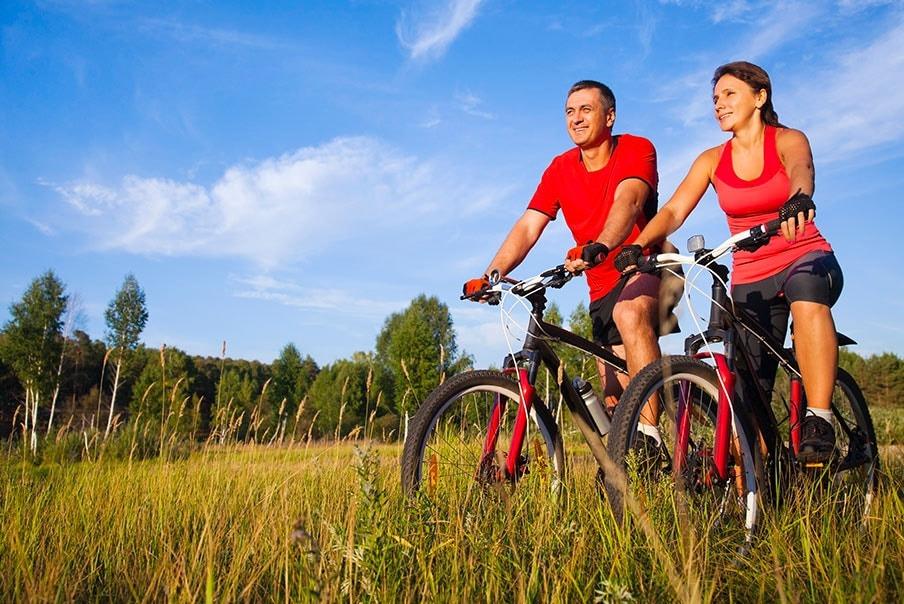 Coppia che si mantiene in forma Uomo e donna in mountain bike